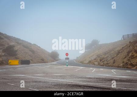 Round red prohibitory road sign with word stop on empty asphalt roadway in dry rural terrain Stock Photo