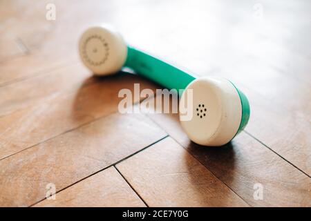 High angle of vintage telephone handset placed on parquet floor in cozy room Stock Photo