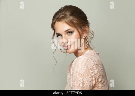 Pretty woman with fashionable hairdo and pastel makeup on white background Stock Photo