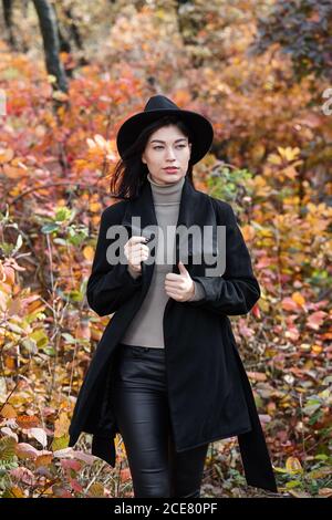 Woman in black clothing with in autumn forest, witch character Stock Photo