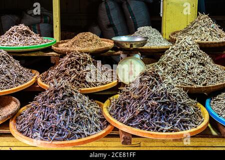 Piles of delicious dried anchovy on plates placed on stall at local fish market Stock Photo