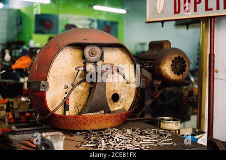 Grunge key making machine and pile of keys placed on weathered table in shabby workshop Stock Photo