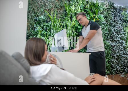 Medical center employee doing an inhalation to the client Stock Photo