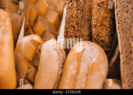 Fresh assorted cut bread and buns served in tray on white table during breakfast Stock Photo