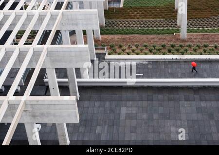 Part of modern house roof with many metallic beams with rusty surface inside and geometrical fence under smooth grey panel in daytime Stock Photo