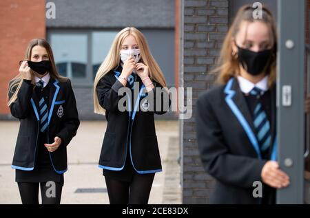 (left to right) Leah McCallum, Rebecca Ross and Sarah Watt, S4 students at St Columba's High School, Gourock, put on their protective face masks as the requirement for secondary school pupils to wear face coverings when moving around school comes into effect from today across Scotland. Stock Photo
