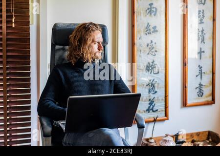 Handsome man working at desktop computer at home Stock Photo