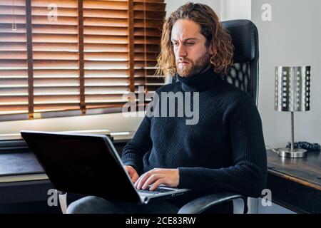 Handsome man working at desktop computer at home Stock Photo
