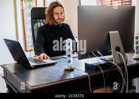 Handsome man working at desktop computer at home Stock Photo