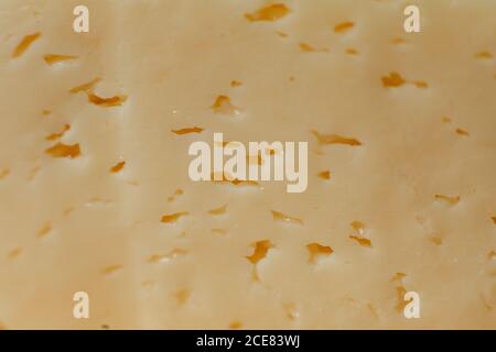 Yellow, fresh cheese with holes, wallpaper Cheese in the form of texture, background Stock Photo