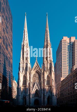 Low angle exterior of famous Neo-Gothic styled Cathedral of St Patrick located on Manhattan in New York City against cloudless blue sky in sunny day Stock Photo