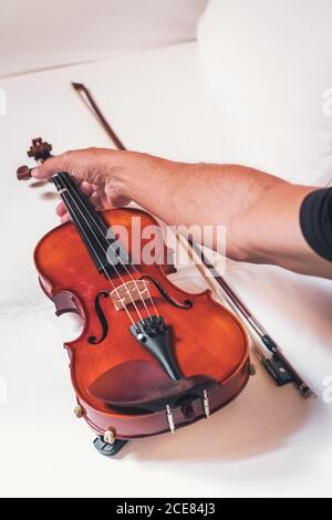 unrecognizable ethnic male violinist with shiny violin and bow on white background Stock Photo