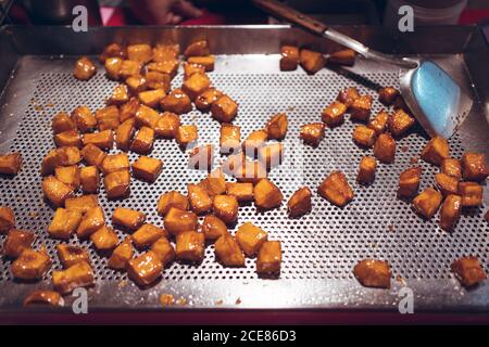 High angle of delicious sugar coated potato cubes scattered on metal counter in Zhubei Night Market Stock Photo
