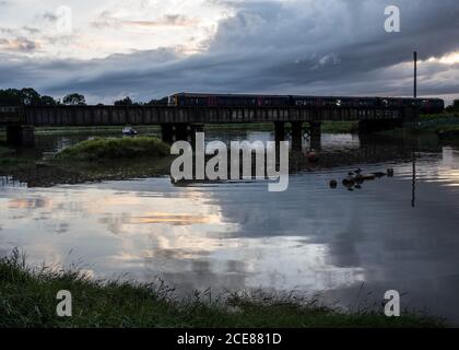 A passenger train crosses the River Trym viaduct at Sea Mills on the Severn Beach Line railway in Bristol. Stock Photo