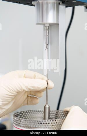 unrecognizable scientist in gloves using viscometer while working in laboratory and conducting chemical experiment Stock Photo