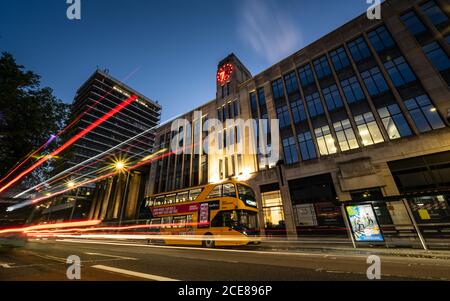 Traffic leaves light trails at dusk in a long exposure photograph of Colston Avenue in central Bristol, with the Colston Tower and art deco 33 Colston Stock Photo