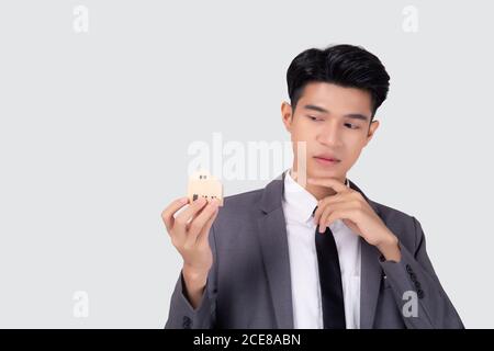 Young asian business man thinking idea and holding the home symbol of planning saving for future, insurance agent and credit, debt and loan of finance Stock Photo