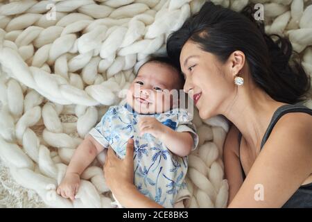 Mother lying with her son in bed Stock Photo