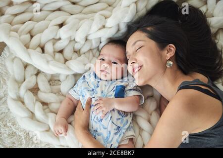 Mother lying with her son in bed Stock Photo