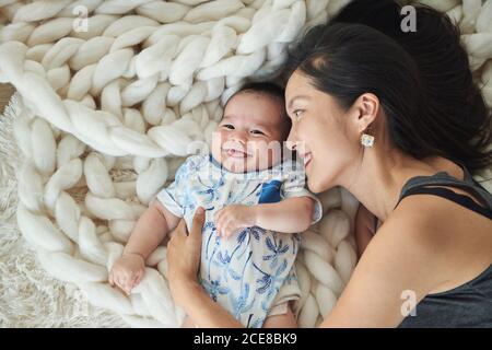 Mother lying with her son in bed Stock Photo