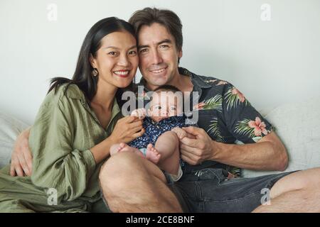 Parents sitting with their son enjoying the time together at home Stock Photo