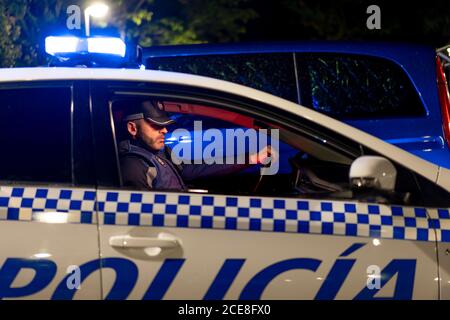 Side view of male police officer sitting in parked automobile with siren light Stock Photo