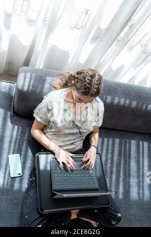 Young Woman with headphones using laptop at home Stock Photo