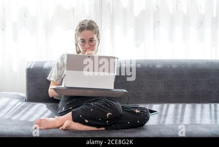 Young Woman with headphones using laptop at home Stock Photo