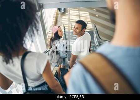 Indian male with beautiful woman standing on the moving staircase Stock Photo