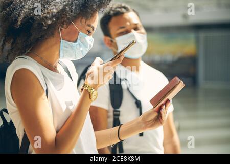 Good looking African female taking photo her document on mobile phone Stock Photo