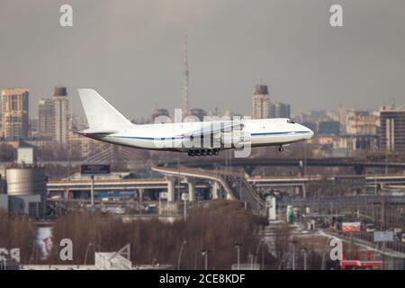 Largest cargo and military strategic airplane taking off at sunny day, St. Petersburg from a high point on background Stock Photo