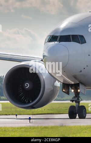 Close up of passenger airplane taxiing on the runway in summer day, front view. Stock Photo