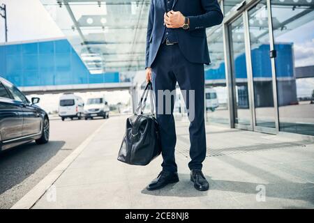 Well-dressed male traveler posing in front of an airport Stock Photo