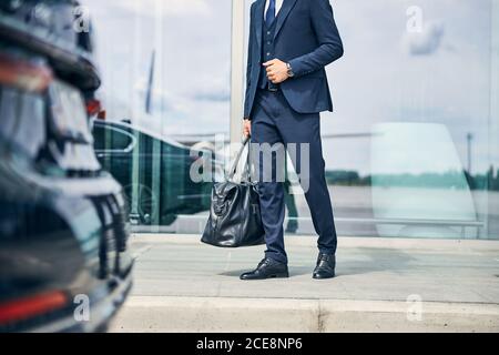 Elegantly dressed man walking towards an automobile Stock Photo