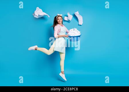 Full length body size view of her she nice attractive cheerful cheery girl maid jumping holding in hand laundry bowl throwing things isolated on Stock Photo