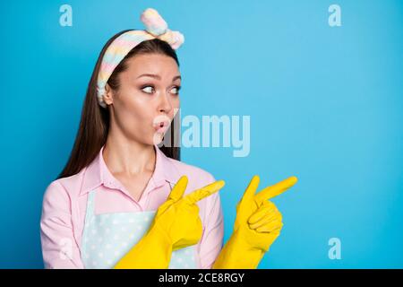 Portrait of astonished girl impressed point index finger copyspace indicate incredible adverts promotion wear pink shirt rubber gloves isolated over Stock Photo