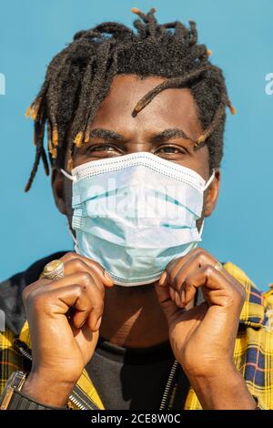 vertical closeup of an attractive young black man wearing a protective mask, lifestyle concept and covid protection Stock Photo