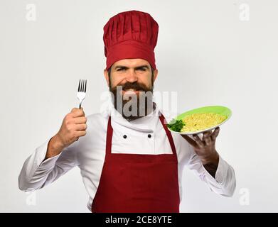 Man chef with fork and spaghetti, pasta noodles, smiling over white background. Cooking and gourmet food concept Stock Photo
