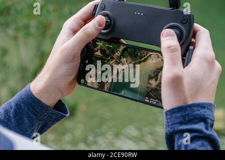 unrecognizable male with remote controller operating unmanned drone and recording video of spectacular landscape Stock Photo