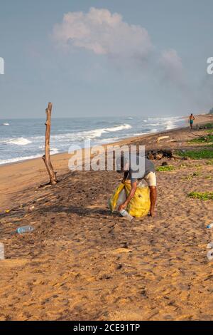 Sri Lanka, Waduwa, Pollution on beach. Plastic. Poor fisher man collecting empty plastic bottle for re-use. Stock Photo