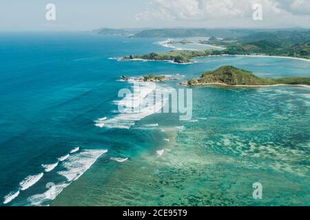 Aerial drone view of Lombok island coastline. Tanjung Aan bay. Amazing landscape with ocean waves, clear water and coral reef. Stock Photo