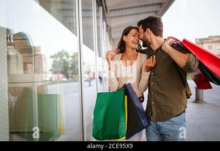 Young attractive happy couple with shopping bags outdoors Stock Photo