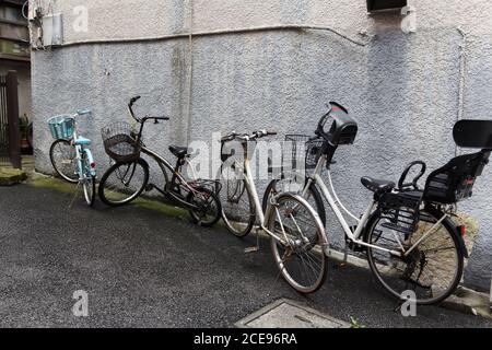 Old bicycles against a house exterior wall. Stock Photo