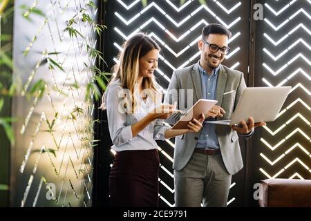 Cheerful coworkers in office working and brainstorming together Stock Photo