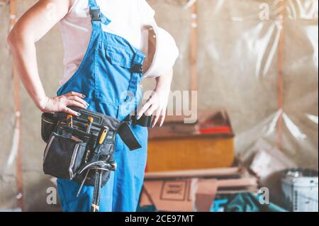 A young woman uses a screwdriver to screw the wood screws into the boards.  Stock Photo