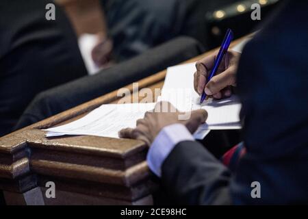 Business Man/Woman making notes at a conference seminar Stock Photo