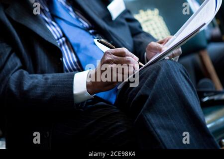 Close up of a man in a suit making notes at a conference seminar Stock Photo