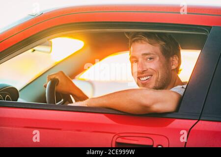 Road trip summer travel vacation man driving electric car sportscar . Male driver at window behind wheel of new eco-friendly green energy vehicle in Stock Photo