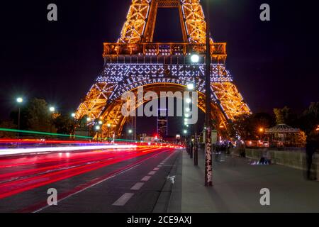 France. Night at the foot of the Eiffel Tower. Heavy traffic and peoples on the Jena bridge Stock Photo