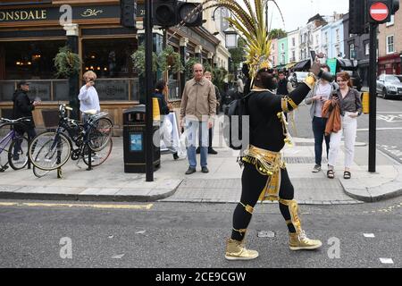 A man in costume heading to take part in the online Notting Hill Carnival, north London, after the 2020 carnival was cancelled due to the coronavirus pandemic, with events being streamed online. Stock Photo